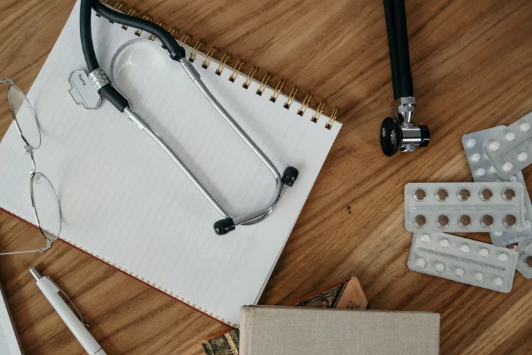 Stéthoscope, carnet et médicaments sur un bureau