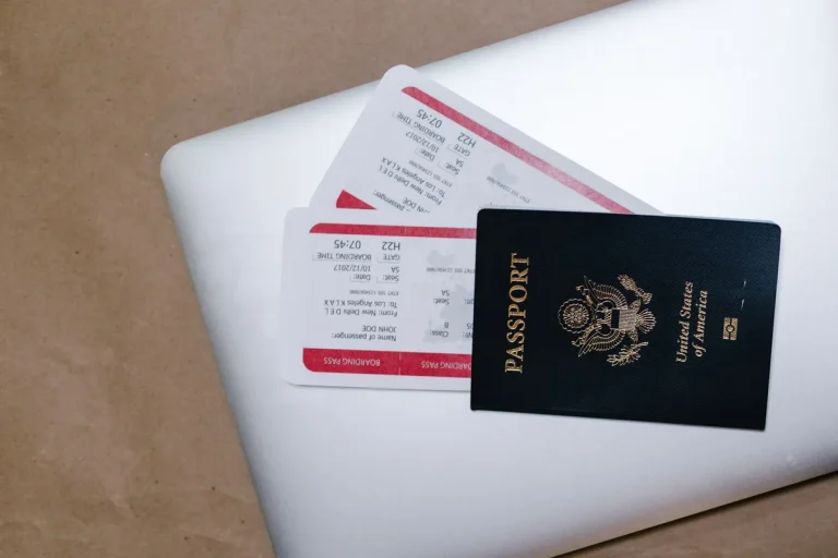 Passeport et billets d'avion posés sur un ordinateur portable