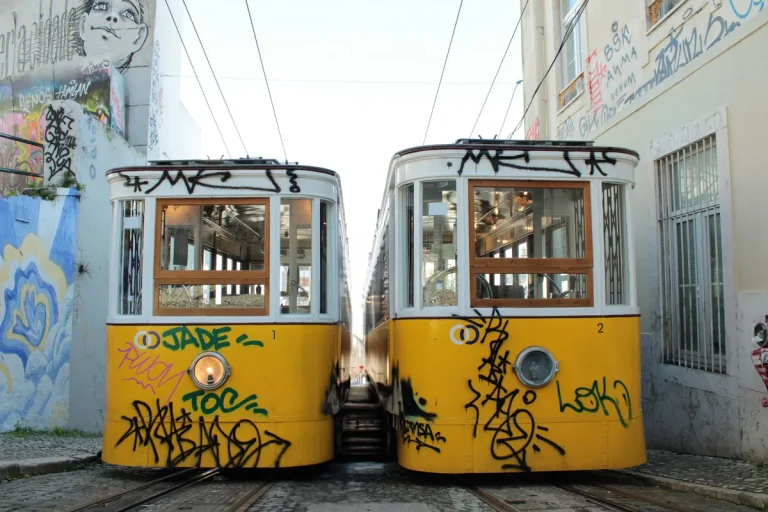 Deux tramways jaunes de Lisbonne dans une rue étroite