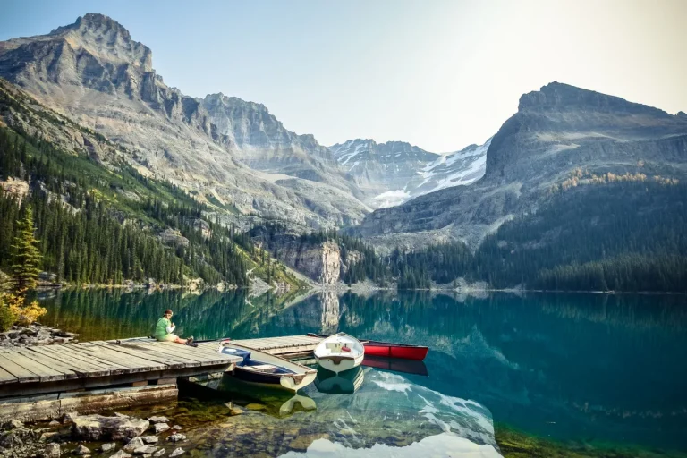 Lac de montagne aux eaux claires et barques amarrées à un ponton