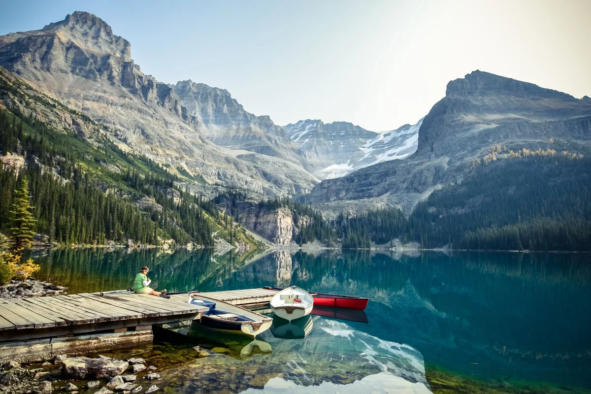 Lac de montagne aux eaux claires et barques amarrées à un ponton
